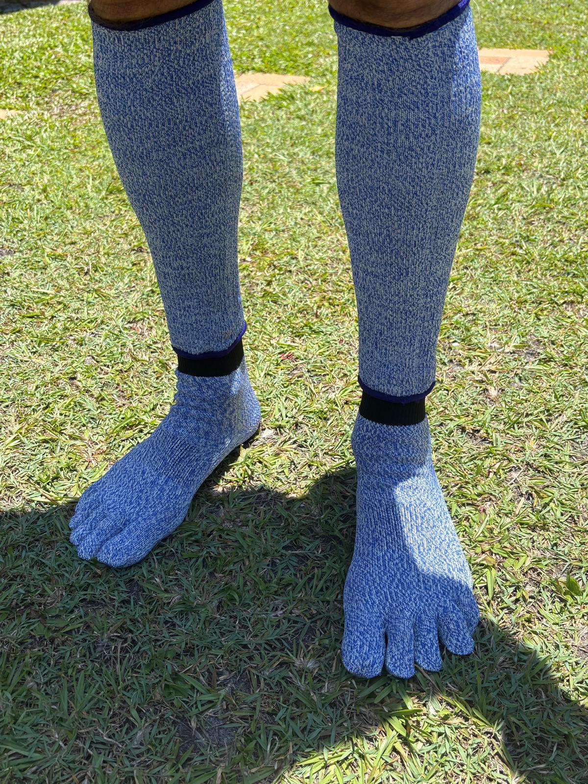 Blue toe-separated socks worn on grass