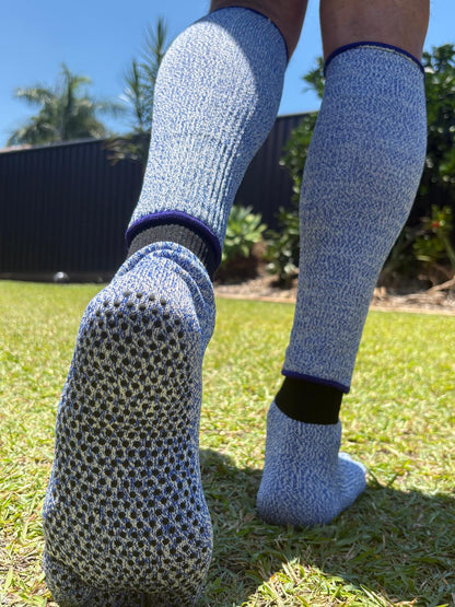 Person wearing blue textured socks on grass with a blurred background