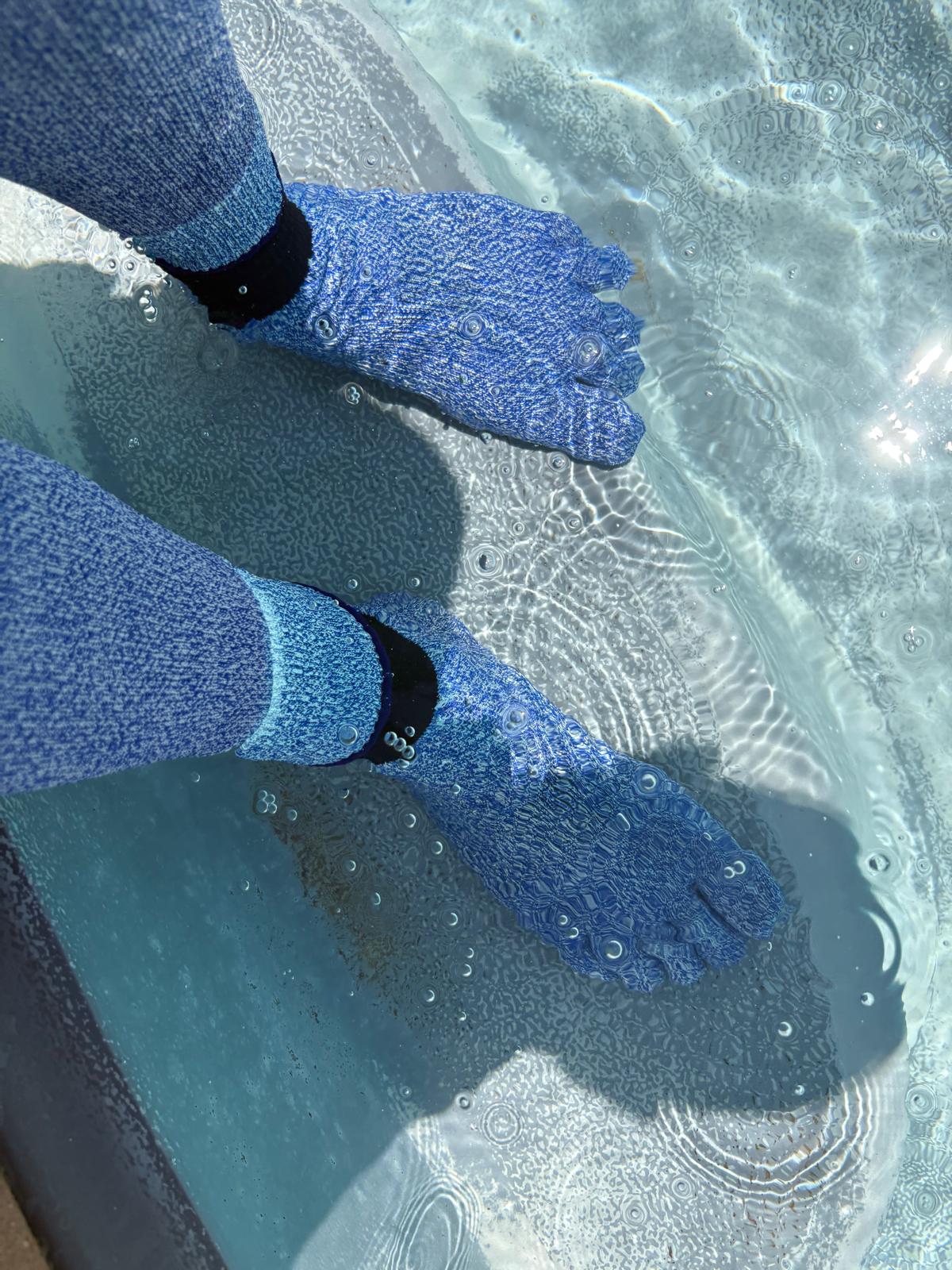 Blue textured socks worn in clear water
